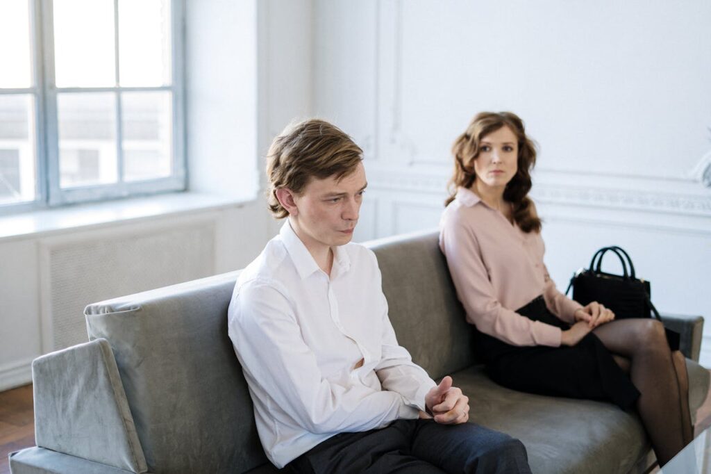 zipwp-image-4098159 Man in White Suit Sitting Beside Woman in Black Dress